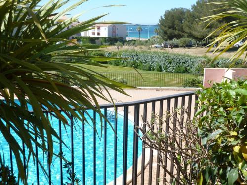 d'un balcon avec vue sur la piscine. dans l'établissement T2 DANS DOMAINE PRIVE PISCINE TENNIS PARC PARC AQUATIQUE VUE MER ET PLAGE, à Six-Fours-les-Plages