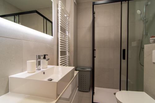a white bathroom with a sink and a shower at Flexible SelfCheckIns 63 - Zagreb - Parking - Loggia - Brand New in Zagreb