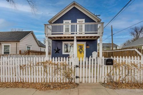 a blue house with a white picket fence at Colorado Springs Home Balcony with Mountain Views! in Colorado Springs
