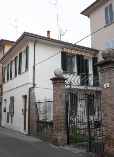a white house with a wrought iron gate at La Casa di Hank - il Centro Storico e l Autodromo in Imola