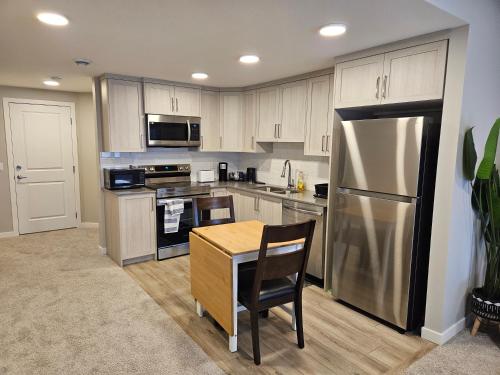 a kitchen with a stainless steel refrigerator and a table at Like cozy place in Calgary