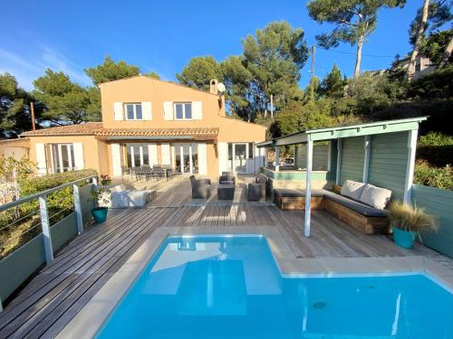 une maison avec une piscine sur une terrasse en bois dans l'établissement Villa Evaluna avec piscine et vue exceptionnelle sur la mer, à Saint-Cyr-sur-Mer