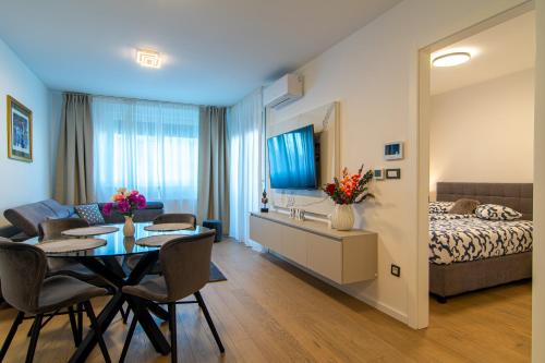 a living room with a bed and a table with chairs at Flexible SelfCheckIns 63 - Zagreb - Parking - Loggia - Brand New in Zagreb