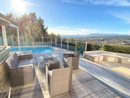 une terrasse avec des chaises et une piscine dans une maison dans l'établissement Villa Evaluna avec piscine et vue exceptionnelle sur la mer, à Saint-Cyr-sur-Mer