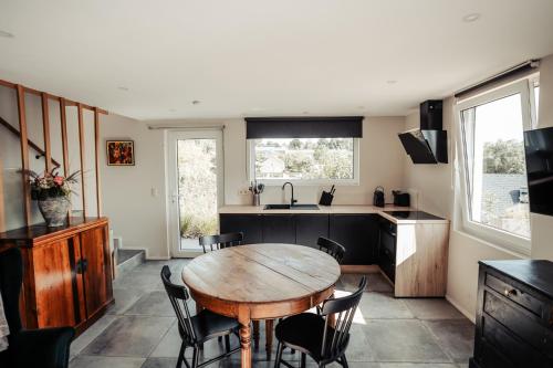 a kitchen with a wooden table and chairs at MY House's - 3 maisons avec piscine commune et la maison pour 3 personnes max avec jacuzzi privé in Vinalmont