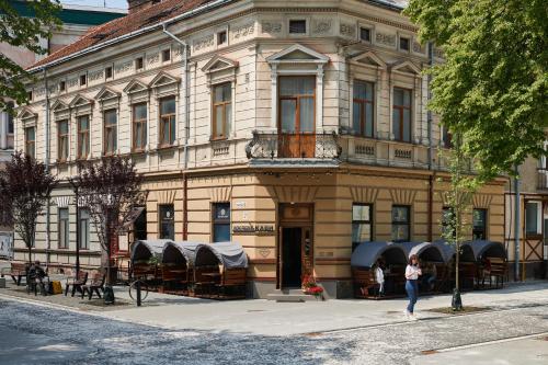 una mujer está parada frente a un edificio en Lama Hostel en Ivano-Frankivsk