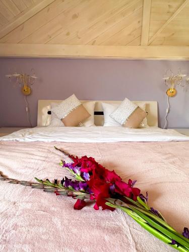 a bed with a bunch of flowers on it at Na Pagorbi Lutsk in Luts'k