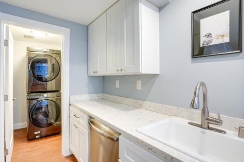 uma cozinha com armários brancos e uma máquina de lavar e secar roupa em Bikeable Apartment - 2 Mi to Downtown Oakland! em Oakland