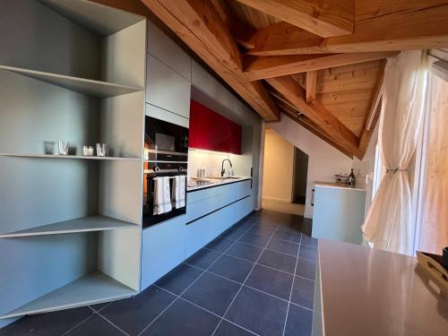 une grande cuisine avec des plafonds en bois et des armoires bleues dans l'établissement Chalet Red Mount - Esprit chalet au pied des pistes, à Les Deux Alpes