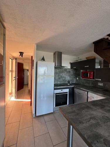 Il comprend une cuisine équipée d'un réfrigérateur blanc. dans l'établissement Agora - Dernier étage - Vue mer, à Argelès-sur-Mer