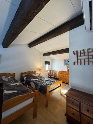 une chambre avec deux lits et une commode dans l'établissement Agora - Dernier étage - Vue mer, à Argelès-sur-Mer