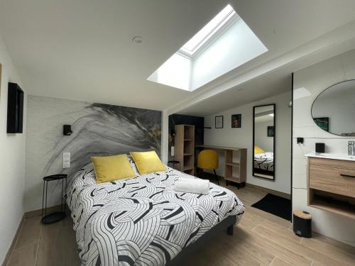 a bedroom with a bed with yellow pillows and a skylight at Résidence Tamaris Loft House in La Mézière