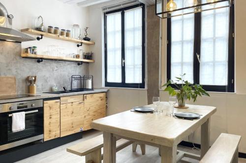 - une cuisine avec une table en bois et quelques fenêtres dans l'établissement L'île Enchantée - Typique - St François, au Havre