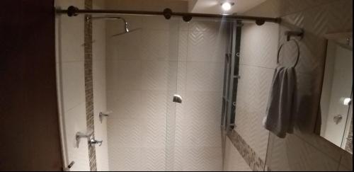 um chuveiro com uma porta de vidro na casa de banho em Apto en conjunto cerrado con piscina. em Ricaurte