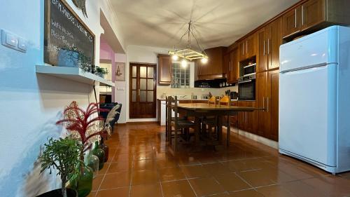 Il comprend une cuisine équipée d'une table et d'un réfrigérateur blanc. dans l'établissement Pátio do Alqueva - Alojamento Local, à Granja