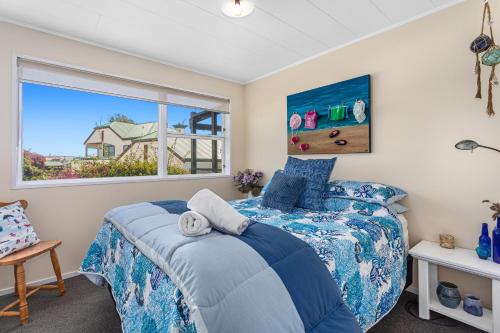 a bedroom with a bed and a window at The Bachela - Ohope Beach Holiday Home in Ohope Beach