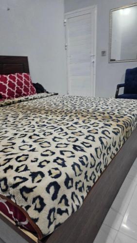 a bedroom with a bed with a black and white comforter at Luxury Hotel Rooms in Karachi