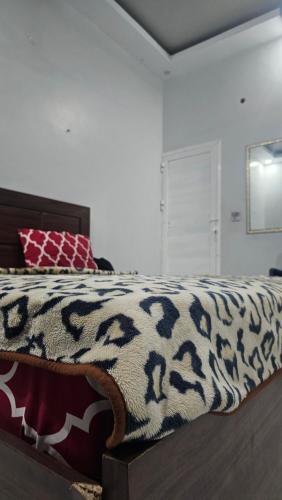 Una cama con una manta blanca y negra. en Luxury Hotel Rooms, en Karachi