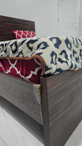 a wooden bed with a blanket on top of it at Luxury Hotel Rooms in Karachi