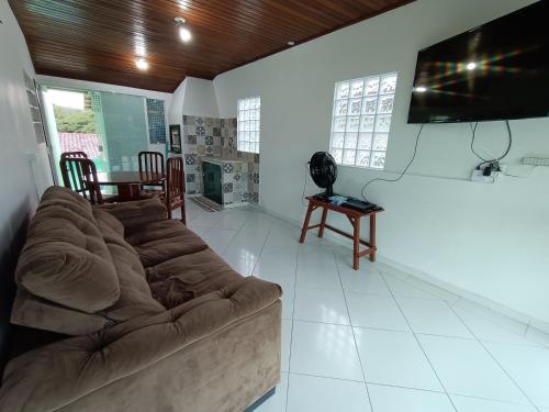 uma sala de estar com um sofá e uma televisão de ecrã plano em HOSTEL CASA DA VÓ ROSA em Governador Celso Ramos