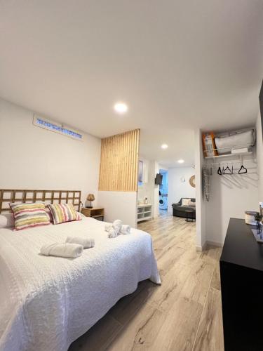 a bedroom with a white bed with towels on it at El descanso del Obispo in Málaga