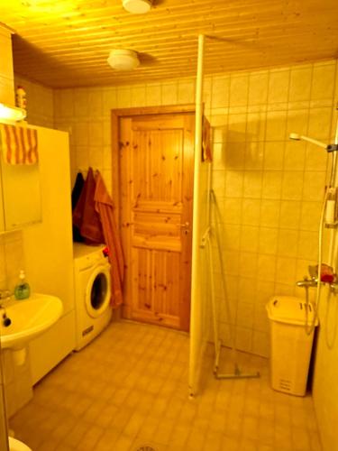 een badkamer met een wastafel, een wasmachine en een droger bij Liepeen pappila in Pudasjärvi