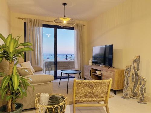 a living room with a television and a couch and a table at AURA MAR Mojácar Apartment in Mojácar