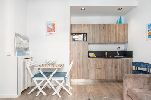 une cuisine et une salle à manger avec une table et des chaises dans l'établissement Large Terrace 1 Bdr near Garibaldi Square, à Nice