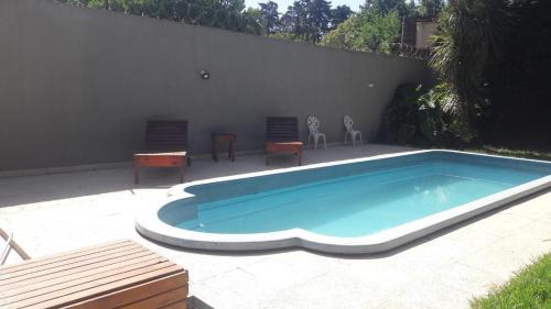 uma piscina com duas cadeiras e uma mesa em Casa quinta tortugas golf em Manuel Alberti