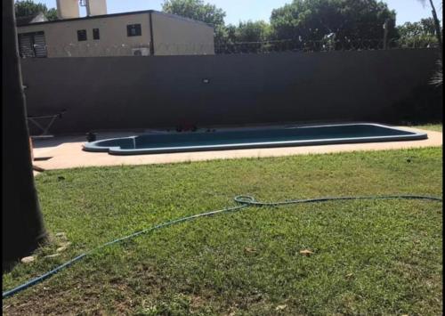 uma piscina com uma mangueira na relva em Casa quinta tortugas golf em Manuel Alberti