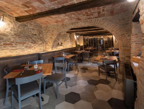 un restaurante con mesas y sillas y una pared de ladrillo en LOCANDA LA SALITA, en Monforte dʼAlba