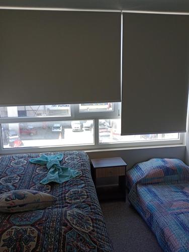 a bedroom with two beds and a large window at Departamento central en Temuco in Temuco