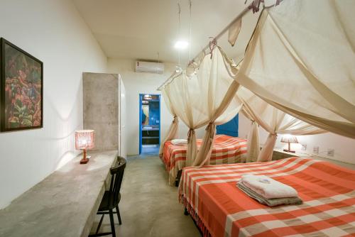a bedroom with two beds and a table with a lamp at Fazenda Poço das Pedras in São João do Cariri