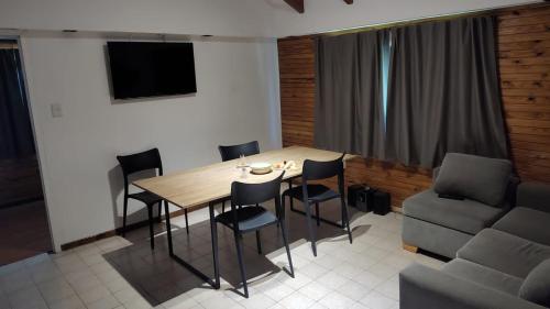 ein Esszimmer mit einem Tisch, Stühlen und einem Sofa in der Unterkunft CABAÑA CASA DE PIEDRA in San Carlos de Bariloche