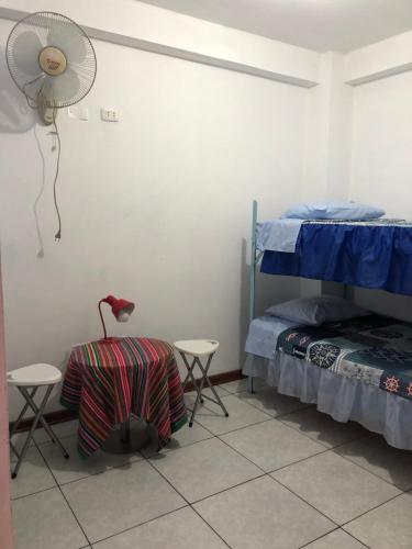 a bedroom with a bed and a fan on the wall at Apartment Near to Lima Airport Perú , El Tip Viajero in Lima