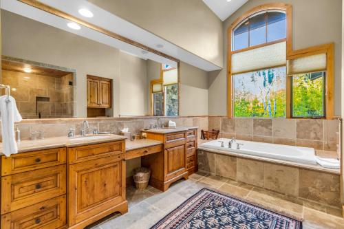 a bathroom with two sinks and a tub and a large window at Serenity at The Colony in Park City
