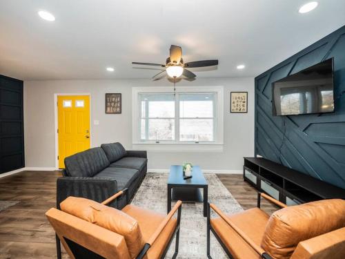 a living room with a couch and a tv at Newly renovated 3 bed/1 bath for visits to DC/UMD! in Hyattsville
