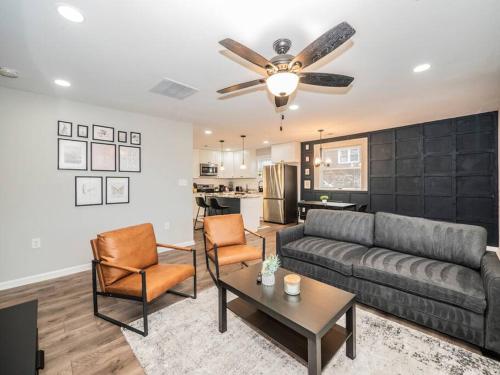 a living room with a couch and chairs and a kitchen at Newly renovated 3 bed/1 bath for visits to DC/UMD! in Hyattsville