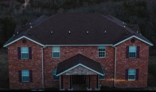a large brick building with a black roof at Luxury Modern Condo by the Lake - Succulent Way in Branson