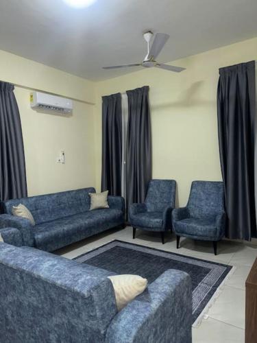 a living room with a blue couch and two chairs at Cozy Luxe Apartment w/ WiFi & AC in Tema