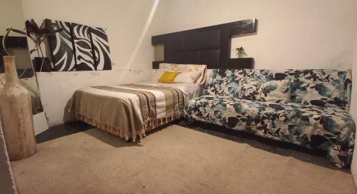um quarto com uma cama e um sofá em Casa Amadis em Querétaro