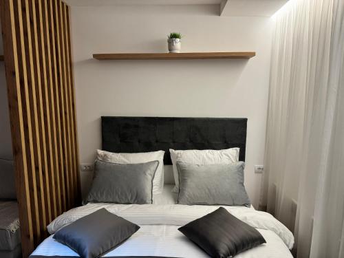 a bedroom with a bed with two pillows on it at Grand Apartman Kopaonik in Kopaonik