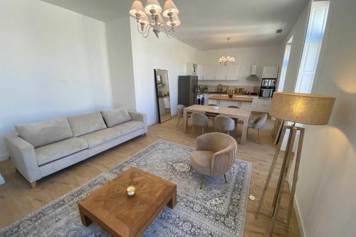 ein Wohnzimmer mit einem Sofa und einem Tisch in der Unterkunft Sunny luxury flat in the city centre in Montpellier