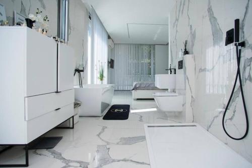 een witte badkamer met een bad en een wastafel bij La Maison Blanche in Écully