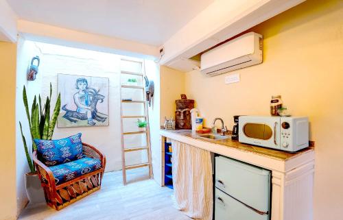 a small kitchen with a microwave on a counter at Charming Basement Studio Guesthouse 2 Blocks from UofA in Tucson