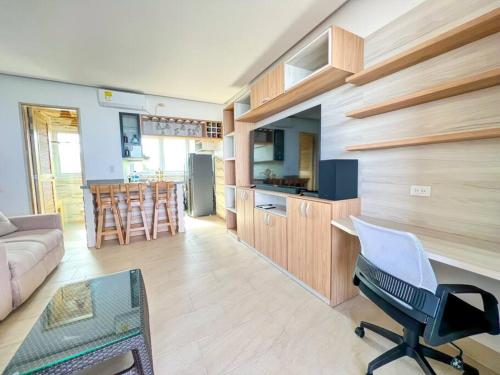 een keuken en een woonkamer met een bank en een stoel bij Suite, Eco Hotel Laguna Beach in Tolú