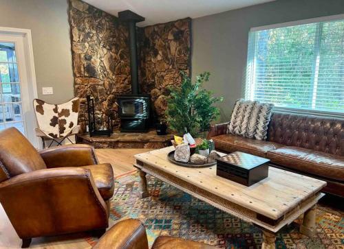Una sala de estar con un sofá de cuero y una mesa de café. en Near Yosemite, A Tranquil Getaway with Creek Frontage, en Oakhurst