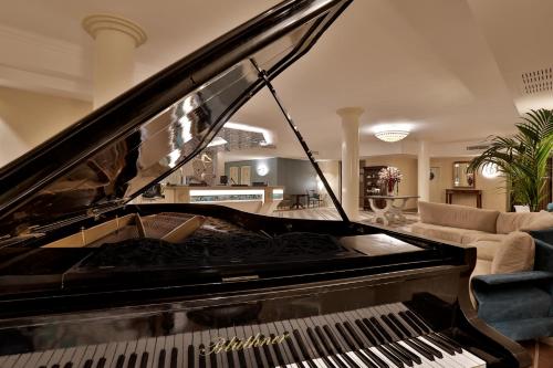 a piano in a living room with a couch at Hotel Hermitage in Galatina