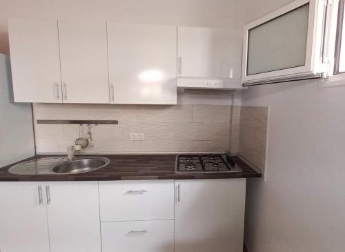 a kitchen with white cabinets and a sink at Casa con jardín y barbacoa cerca del mar in Puerto del Rosario