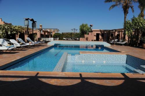 a swimming pool with lounge chairs and a swimming pool at VILLA TATA MARIE MAISON D'HOTES Marrakech in Marrakech